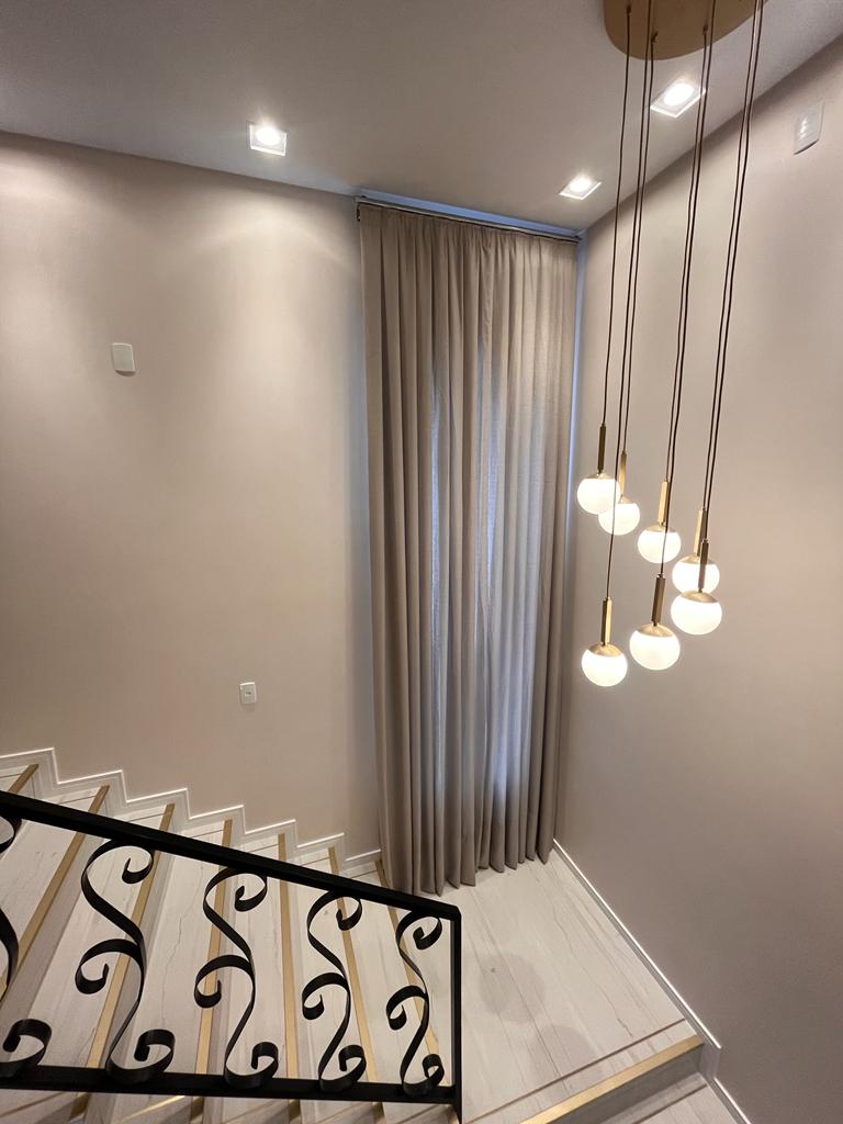 Cortina em pé-direito alto na escada, trabalho da Teris Modas